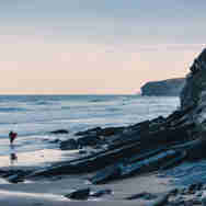Owen Tozer - surfer & cliffs at Watergate Bay beach
