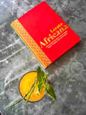 Lerato's Africana cookbook sit on the table next to a glass of juice