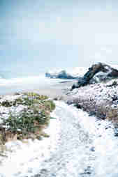 View of the north cliffs covered in snow from the coast path at Watergate Bay