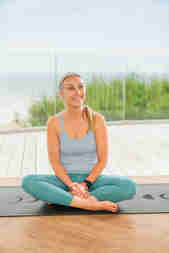Pilates instructor, Marina Huxley sitting cross legged on the floor