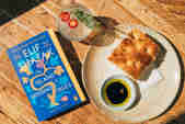 A book beside a plate of bread and oil "The Island of Missing Trees by Elif Shafak"