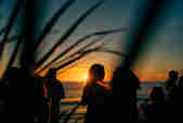 People standing on the deck in front of the sunset