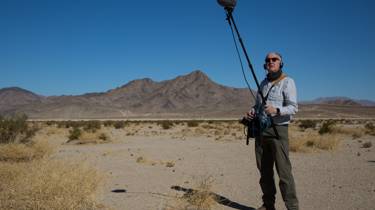Chris Watson with a boom mic in the desert
