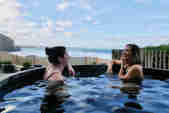 Two women in a sea view hot tub laughing