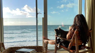 Melissa Hemsley sitting in the beach lofts with a dog