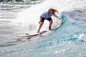 Charlotte Banfield rides a wave on a surfboard