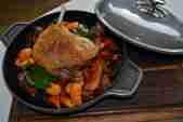 Confit duck leg with vegetables in a pot