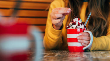 Woman with a mug of origin hot chocolate and cream