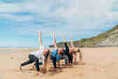 Group yoga session on the beach at Watergate Bay