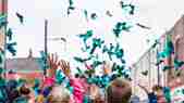 Hands reach up to paper confetti in a Marrs Green colour