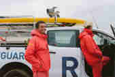 Photo of two RNLI lifeguards and vehicle